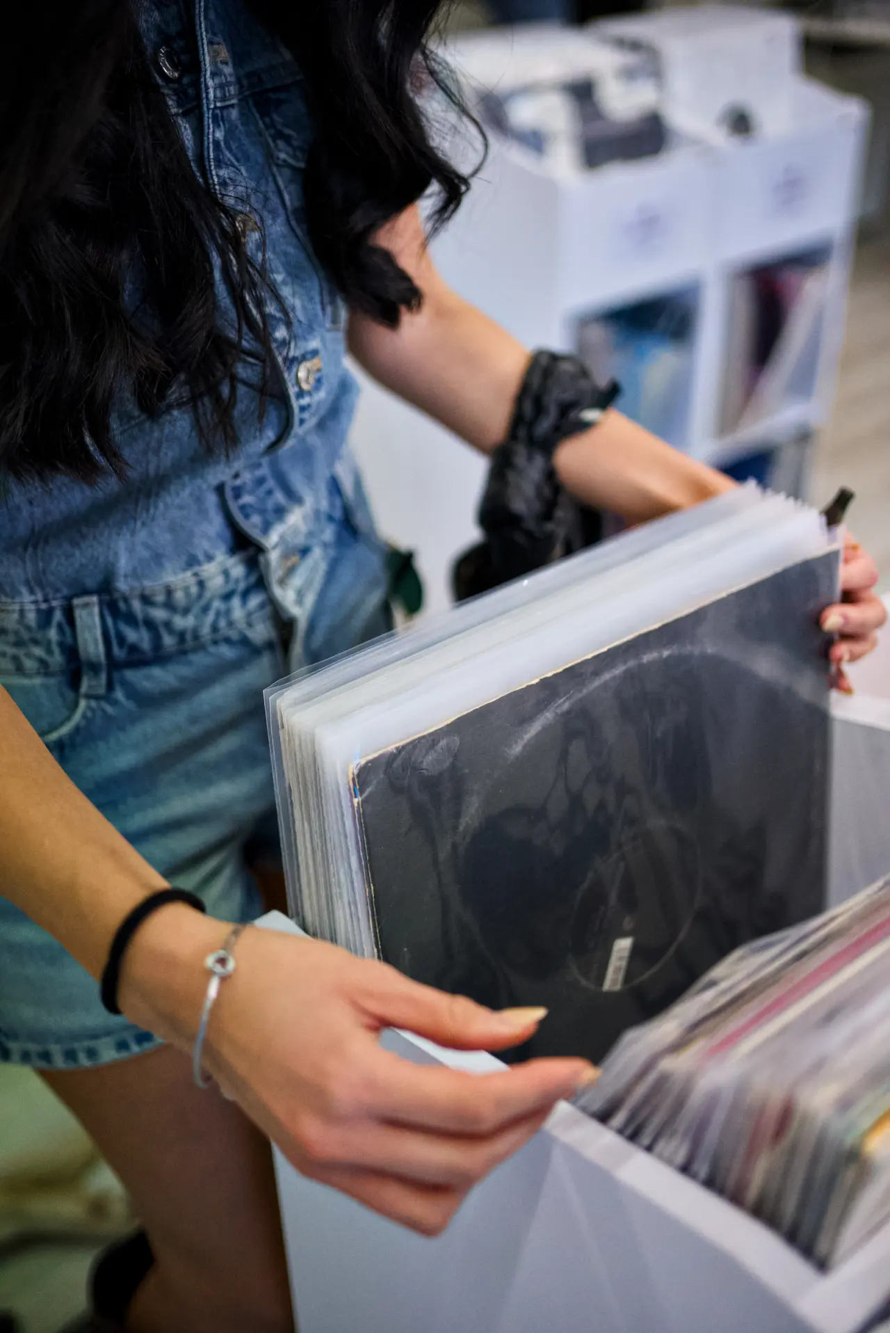 Una cliente sceglie un vinile tra gli scaffali